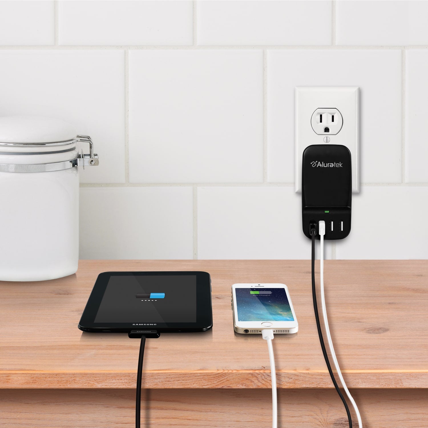 Alluralek power adapter with multiple outlets on a wooden surface, charging a tablet and phone.