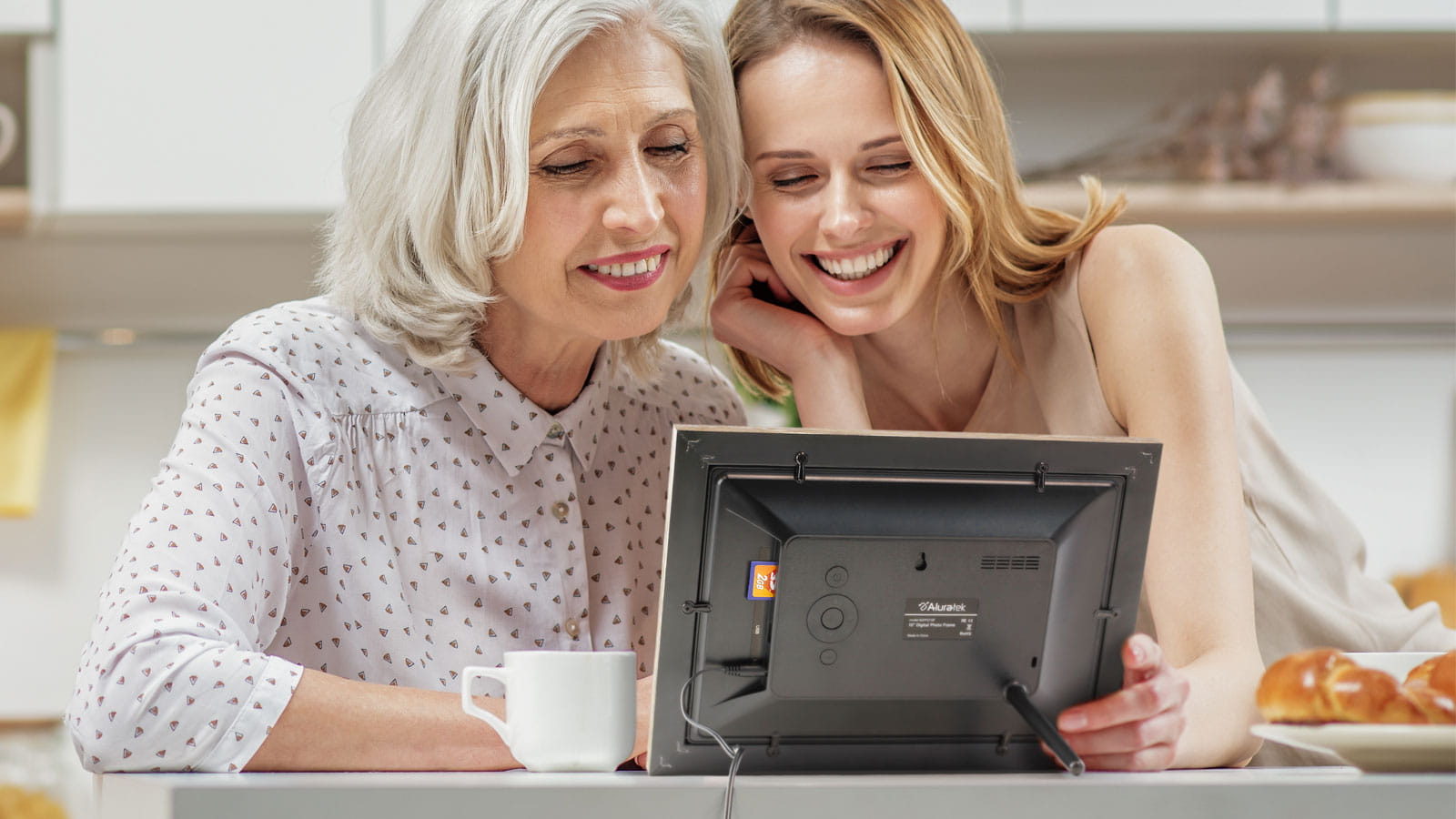 Mother and daughter looking at an Aluratek digital photo frame
