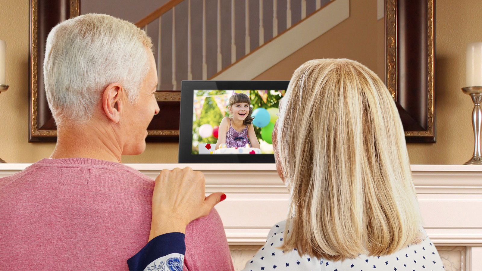 Grandparents looking at an Aluratek digital photo frame